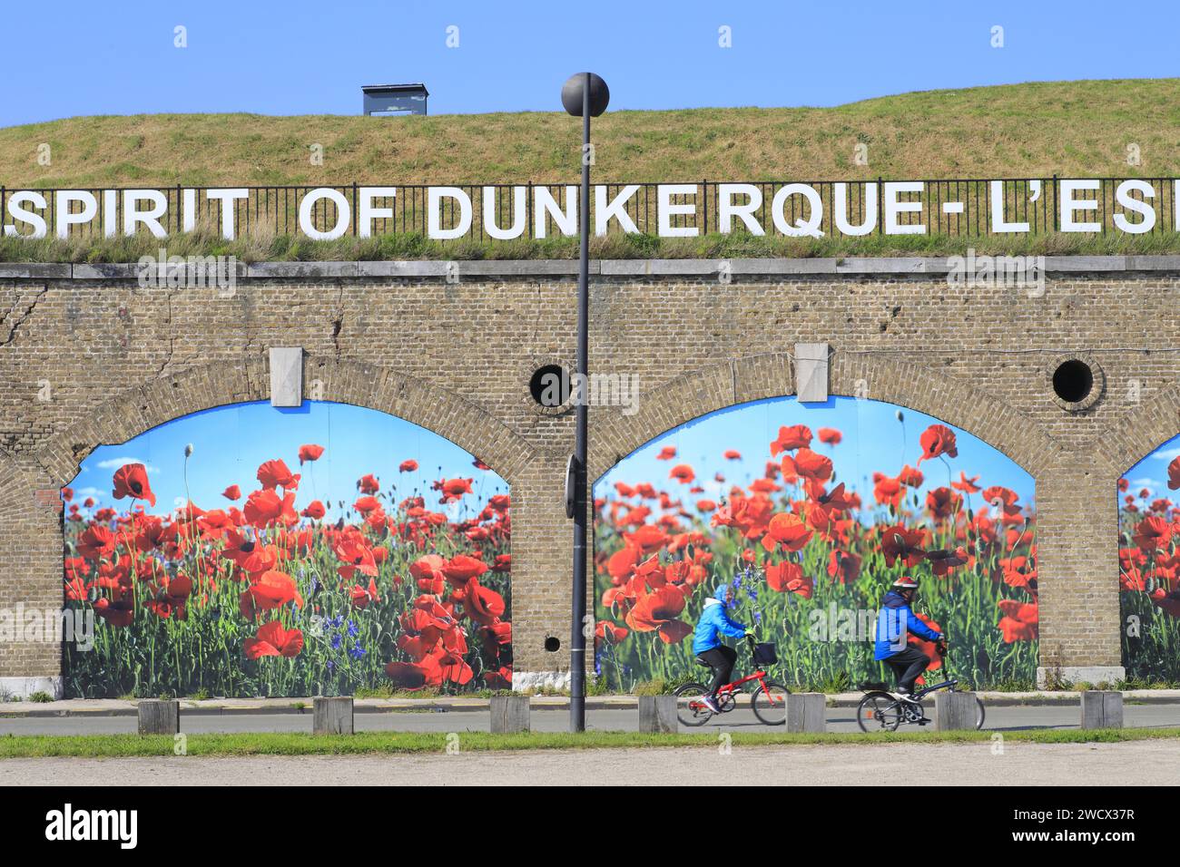 Frankreich, Nord, Dunkirk, Bastion 28, Radfahrer vor der Stadtmauer von 1882, die Teil der alten Festungsanlage mit dem Slogan L'Esprit de Dunkerque war Stockfoto