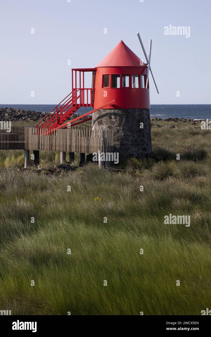 Portugal, Azoren-Archipel, Insel Pico, Lajes de Pico, rote niederländische Windmühle, die mitten in einem Moor mit Blick auf den Ozean liegt Stockfoto