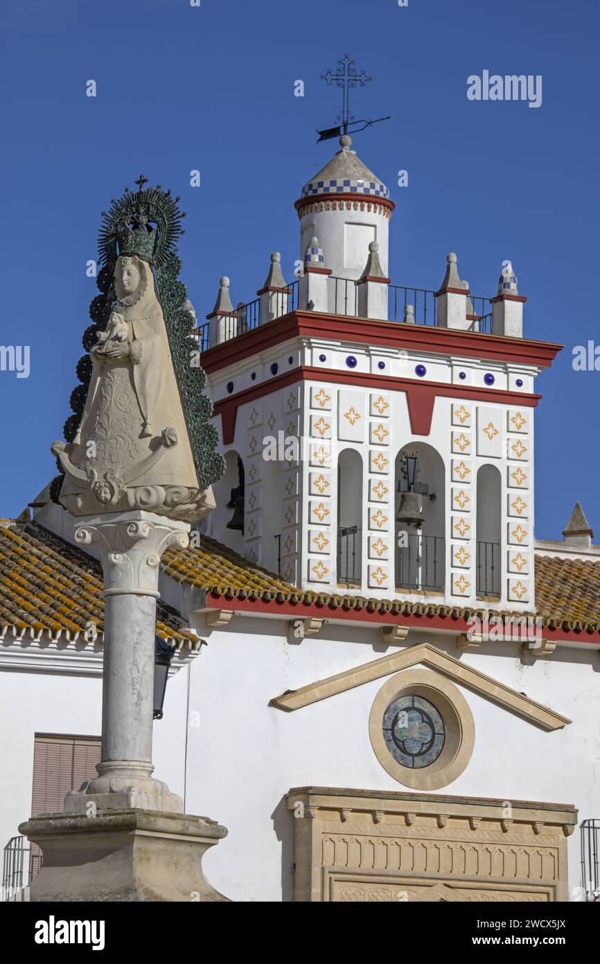Spanien, Andalusien, El Rocío, Statue der Jungfrau von Rocio vor der weißen Fassade einer hermandad, Haus einer katholischen Bruderschaft, gekrönt von einem Turm Stockfoto
