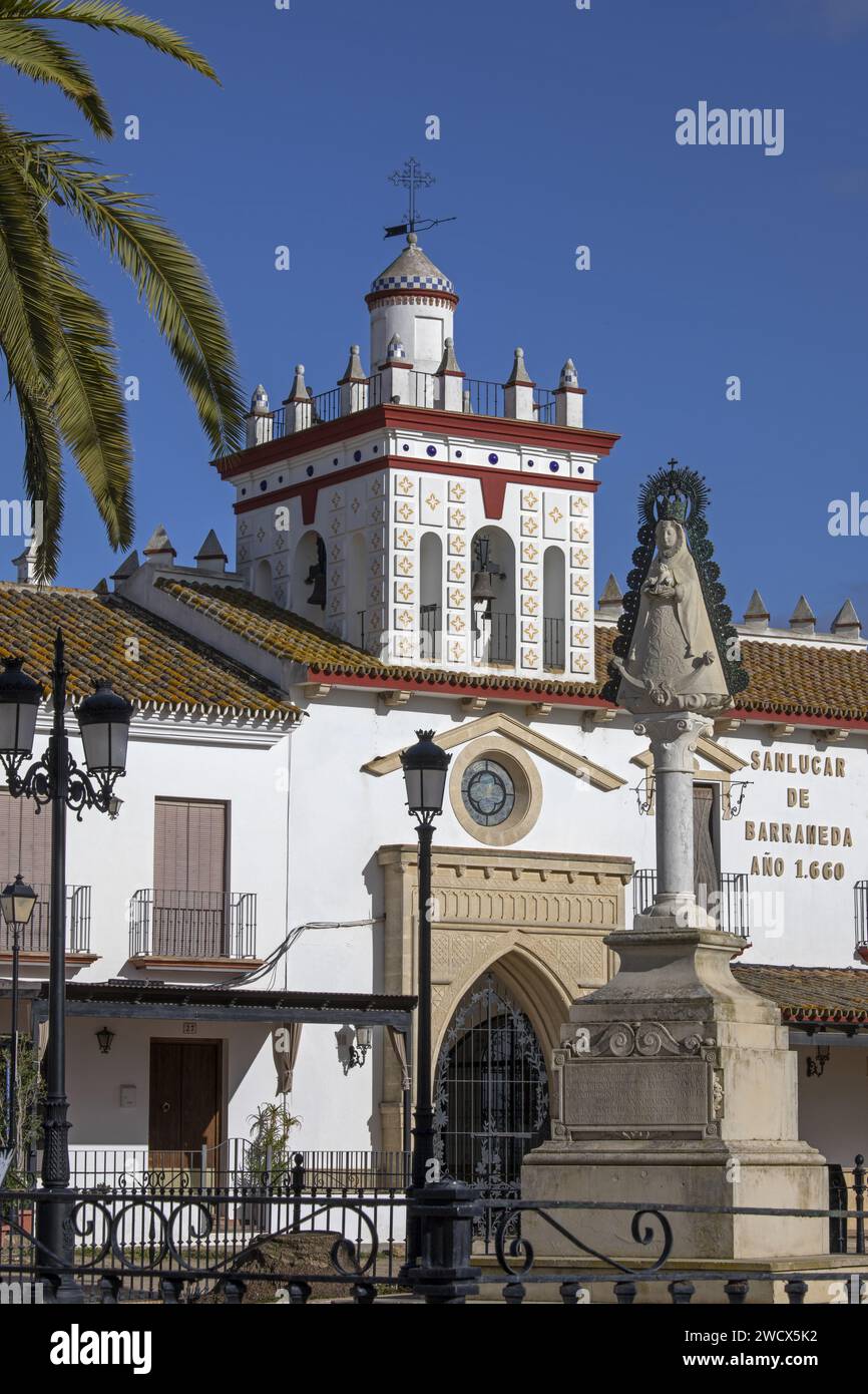 Spanien, Andalusien, El Rocío, Statue der Jungfrau von Rocio vor der weißen Fassade einer hermandad, Haus einer katholischen Bruderschaft, gekrönt von einem Turm Stockfoto