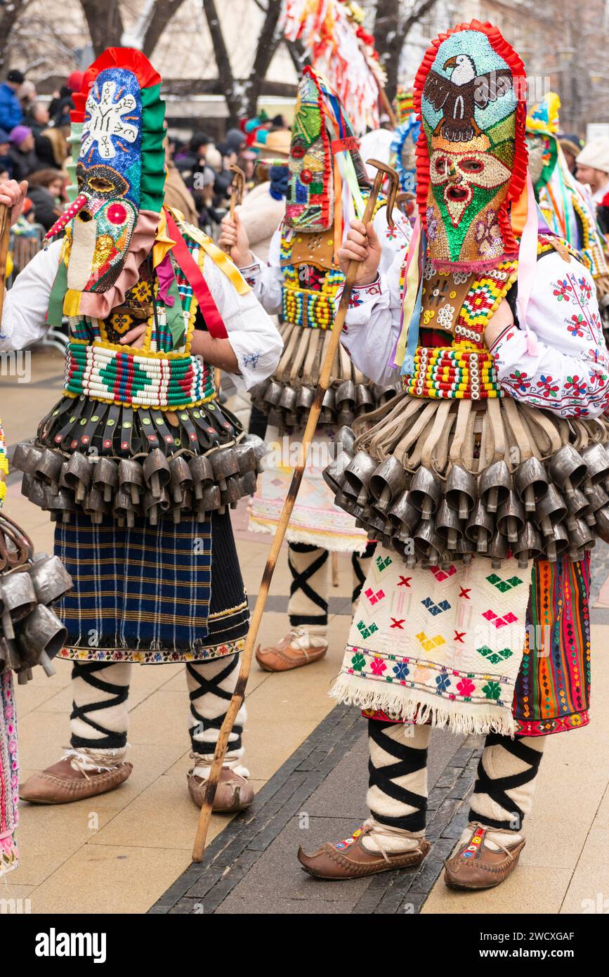 Maskierte Tänzerinnen mit bunten Masken und Kostümen aus der Region Zentralbulgarien beim Kukeri Surva Maskerade und Mummers Festival in Pernik, Bulgarien Stockfoto
