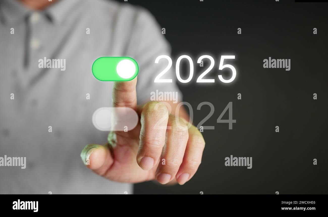 Frohes neues Jahr 2025. Ein Mann, der auf einen ein-Schalter mit 2025 Umschalttaste tippt, um 
