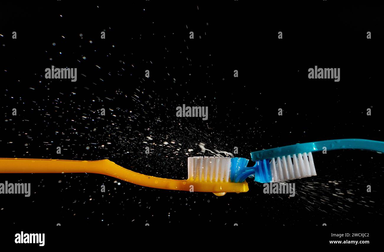 Zwei Zahnbürsten mit Wasserspritzern auf schwarzem Hintergrund. Stockfoto
