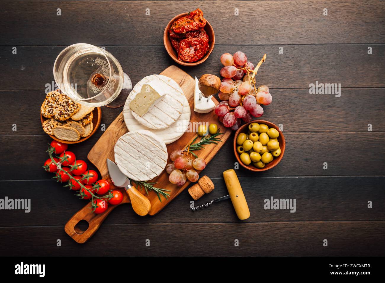 Käseplatte mit Brie, Camembert, Trauben, Oliven und Tomaten Stockfoto