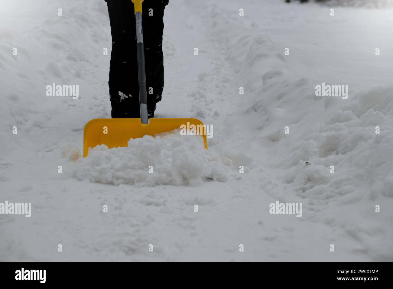 Ein Junge schaufelt Schnee nach einem Schneesturm. Stockfoto