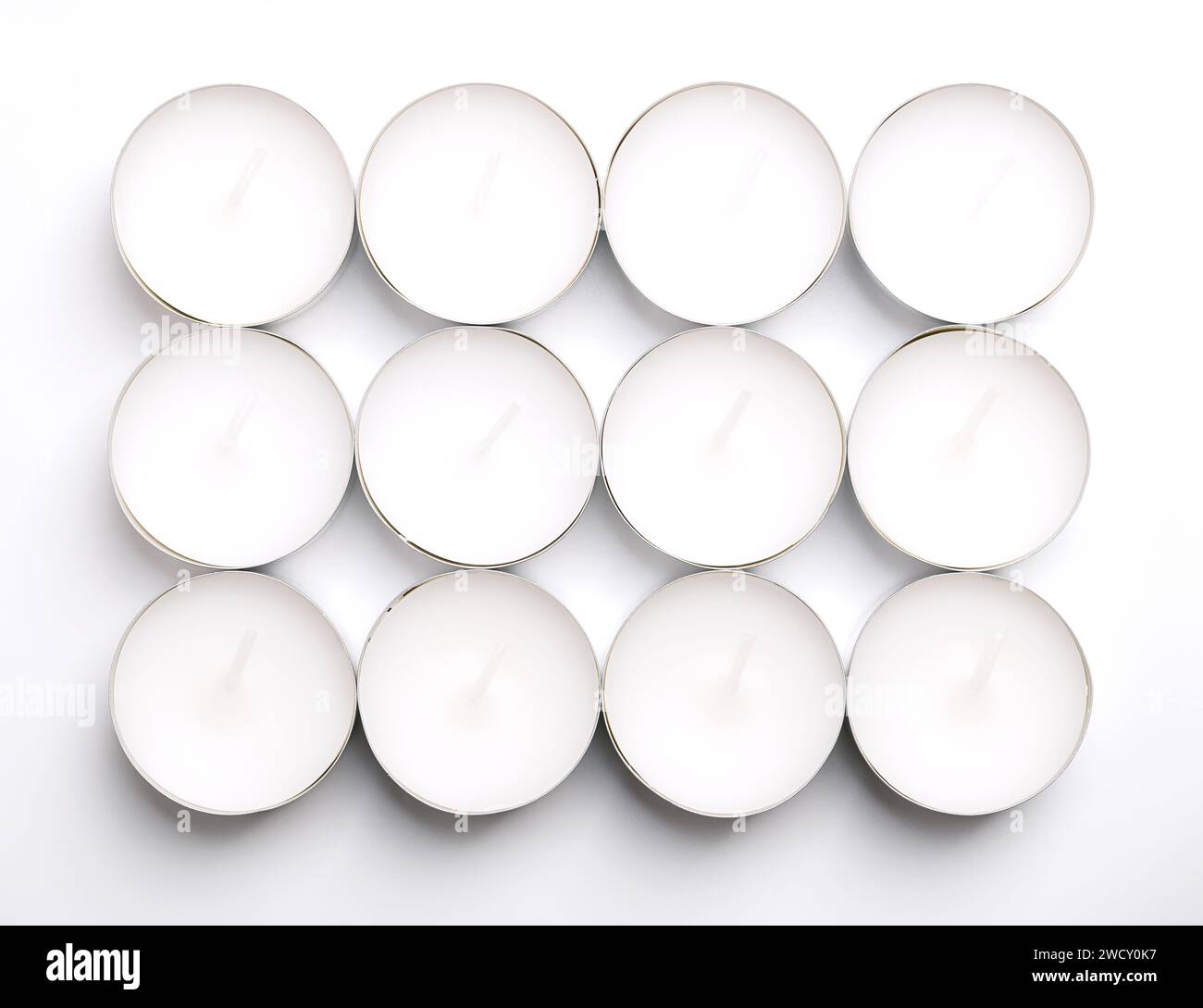 Gruppe von Teelichtern, Kerzen in dünnen Metallbechern, damit das Wachs sich beim Anzünden vollständig verflüssigt. Stockfoto
