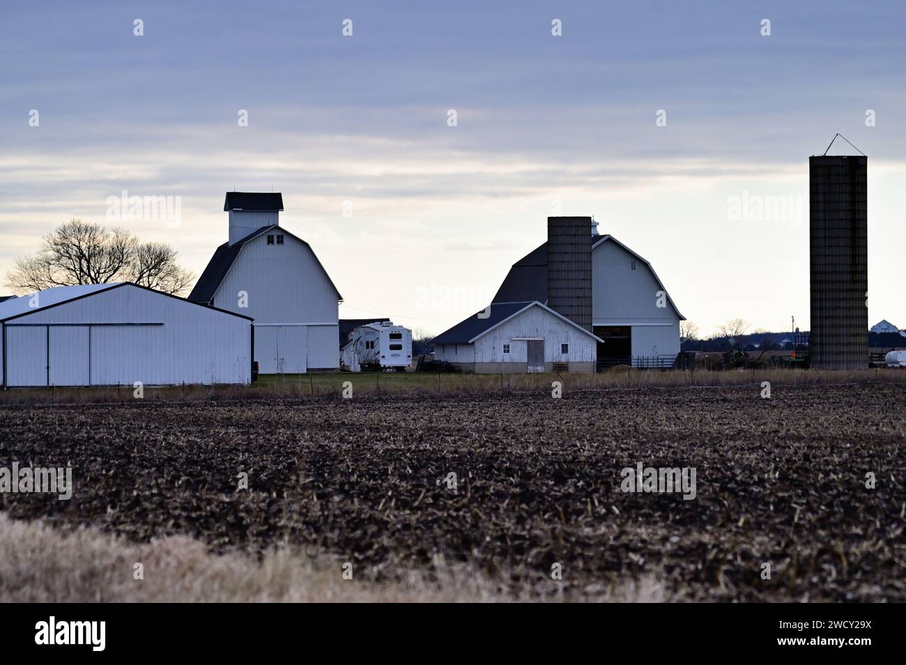 Hinckley, Illinois, USA. Eine Ansammlung von Scheunen und Scheunen befindet sich am frühen Morgen vor einer Pause in den Wolken auf einer Farm in Illinois. Stockfoto