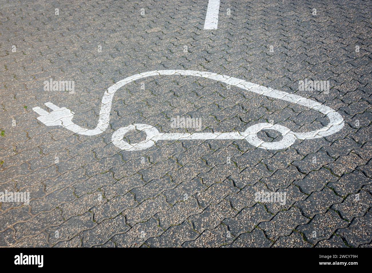 Schild zum Aufladen von Elektrofahrzeugen, das an einer Tankstelle auf der Straße lackiert ist Stockfoto