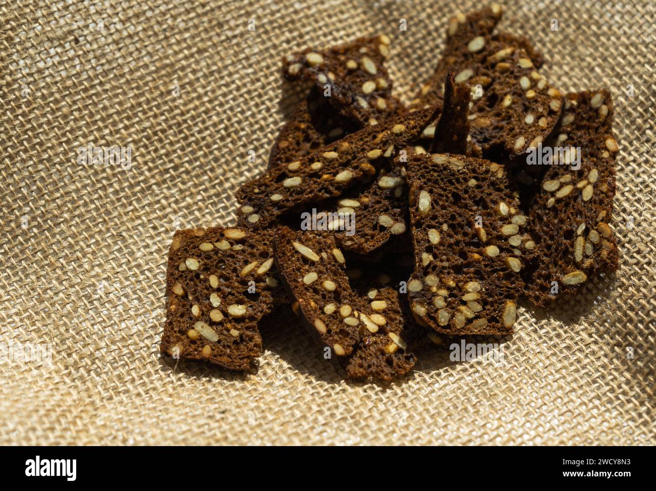 Köstliche dünne Brotcracker aus dunklem Roggen mit Getreidesamen und Sonnenblumen. Dunkle Roggencracker mit Samen Stockfoto