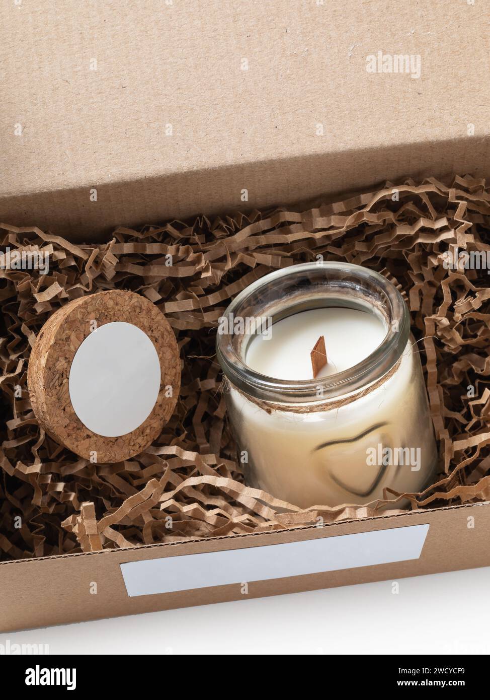 Duftende Kerze in einem Glasgefäß in einer offenen corton-Box Stockfoto