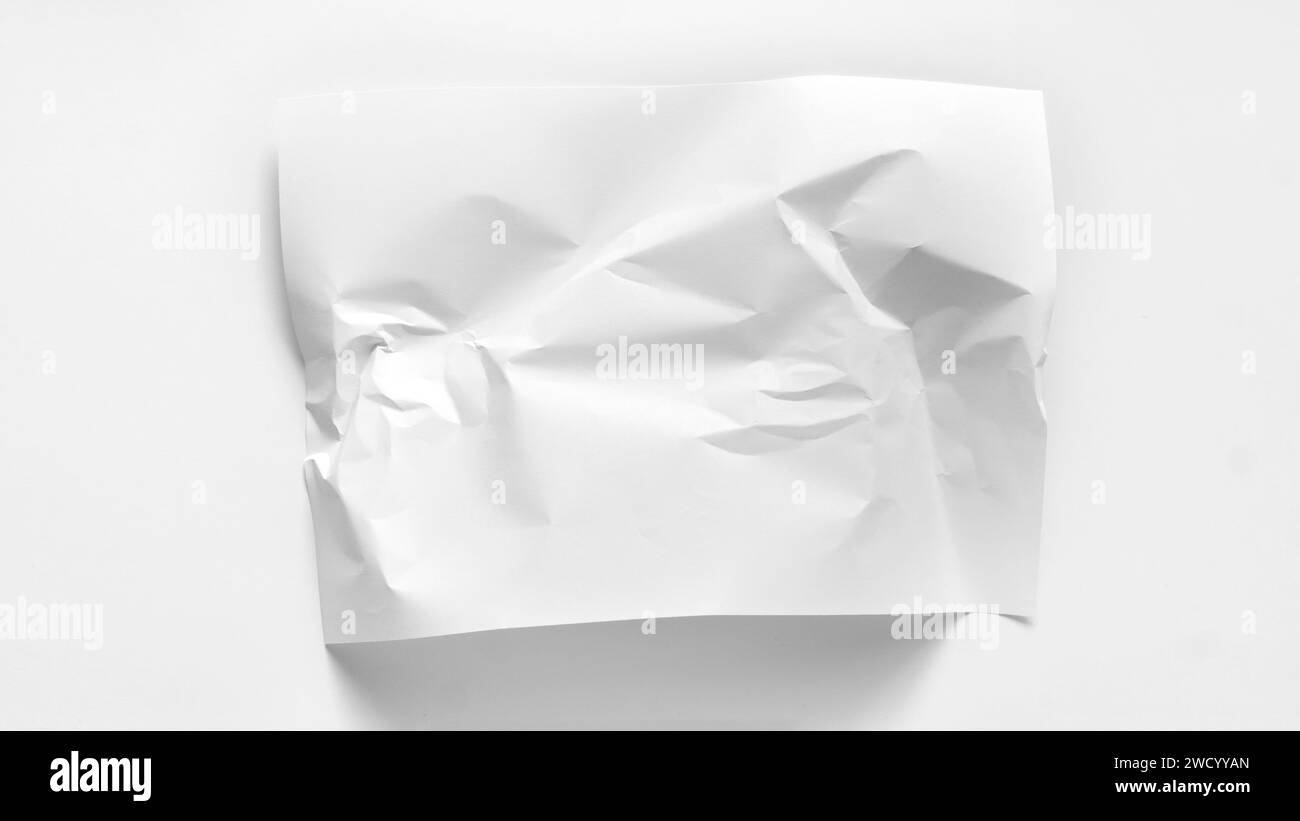 Ein leicht zerknittertes Blatt Papier in Nahaufnahme mit Kopierraum. Ein weißes Blatt Papier ist leicht zerknittert und liegt auf weißem Hintergrund. Modell für in Stockfoto
