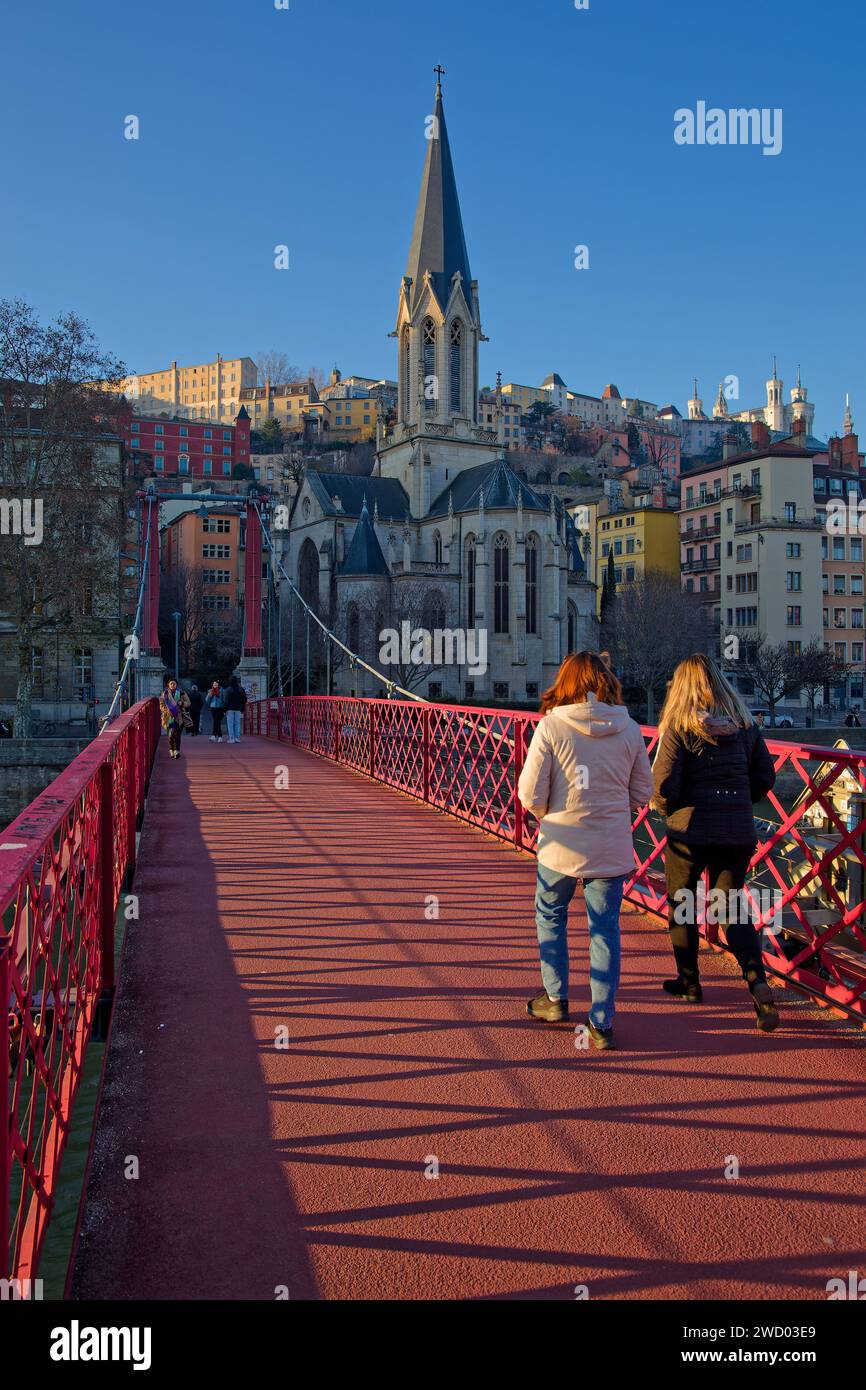 LYON, FRANKREICH, 18. Dezember 2023: Fußgänger überqueren den Saone-Fluss auf der Brücke in der Nähe der Kirche Saint-George im historischen Stadtzentrum Stockfoto