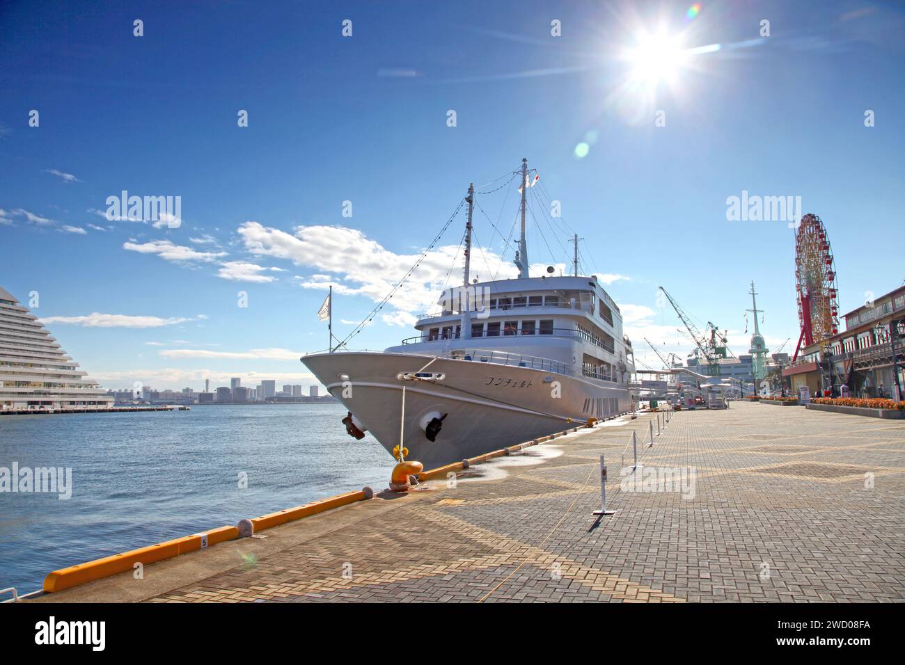 Ein Kreuzfahrtschiff, das neben der Mosaic Mall im Hafen von Kobe in Kobe, Präfektur Hyogo, Japan, vor Anker liegt. Stockfoto