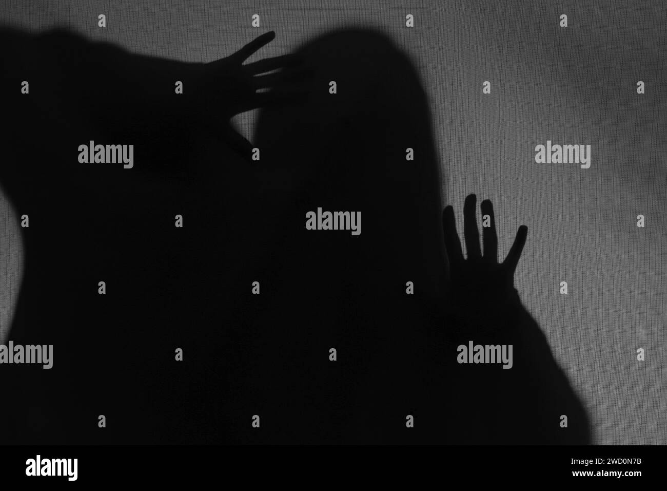 Silhouette eines gruseligen Geistes hinter grauem Tuch Stockfoto