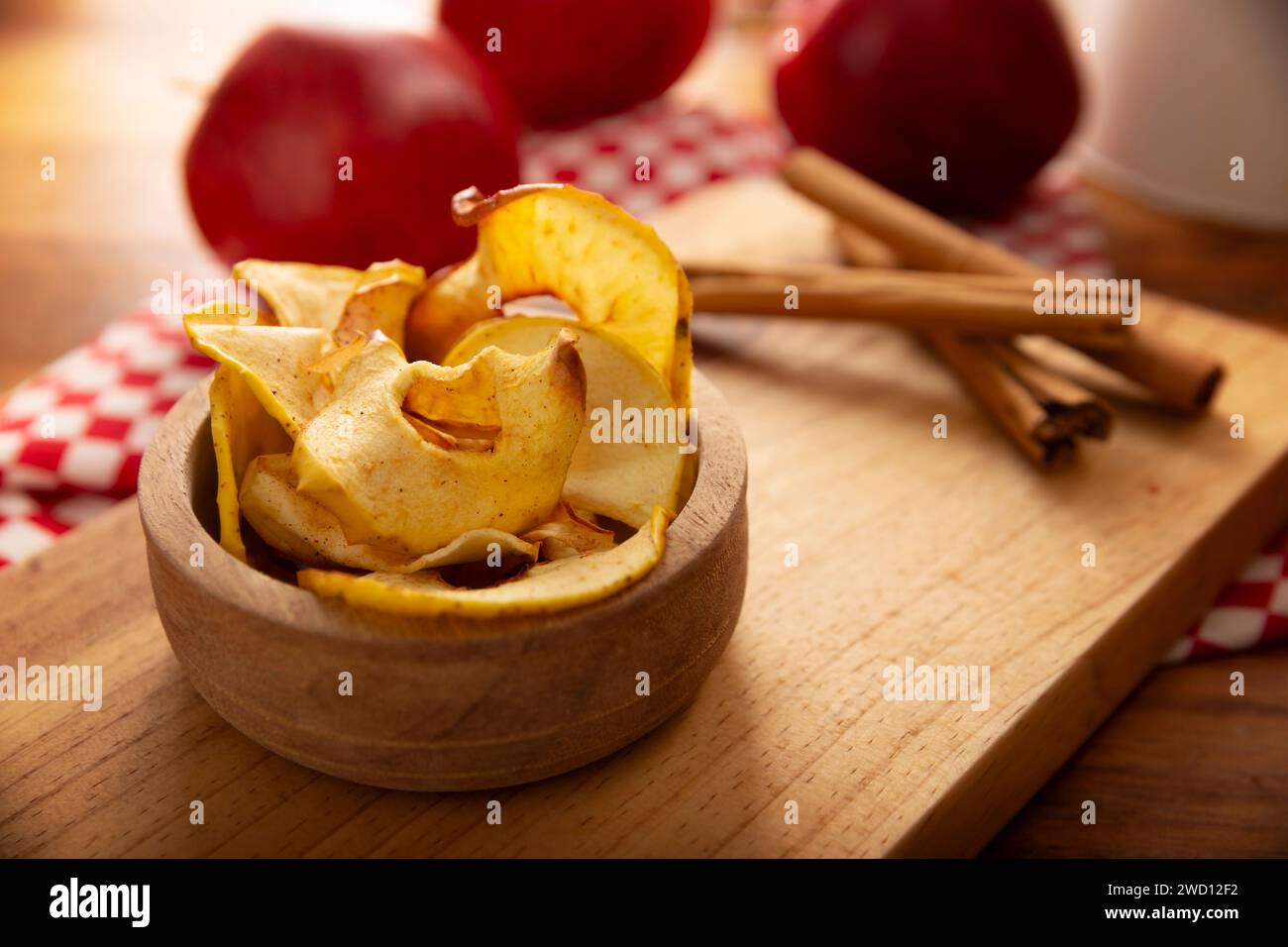 Hausgemachte Apfelchips, dünne Scheiben getrockneten und gebackenen Apfels, bestreut mit Zimtpulver, einfaches Rezept für einen gesunden Snack. Stockfoto