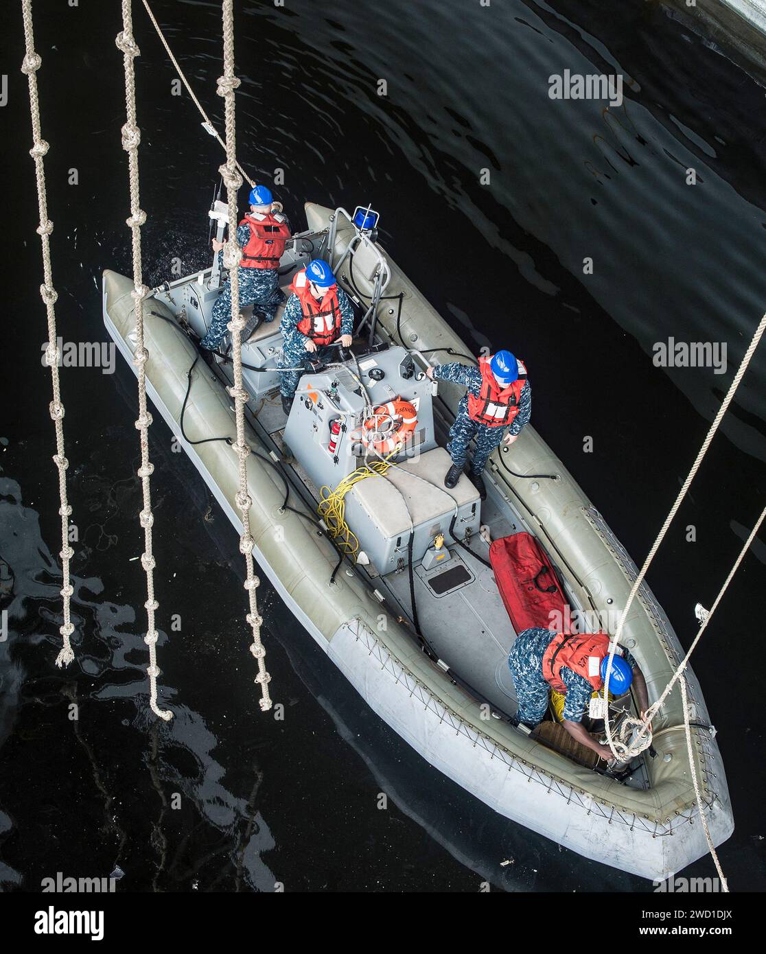 Seeleute entfernen Messenger-Leinen von einem starren Schlauchboot. Stockfoto