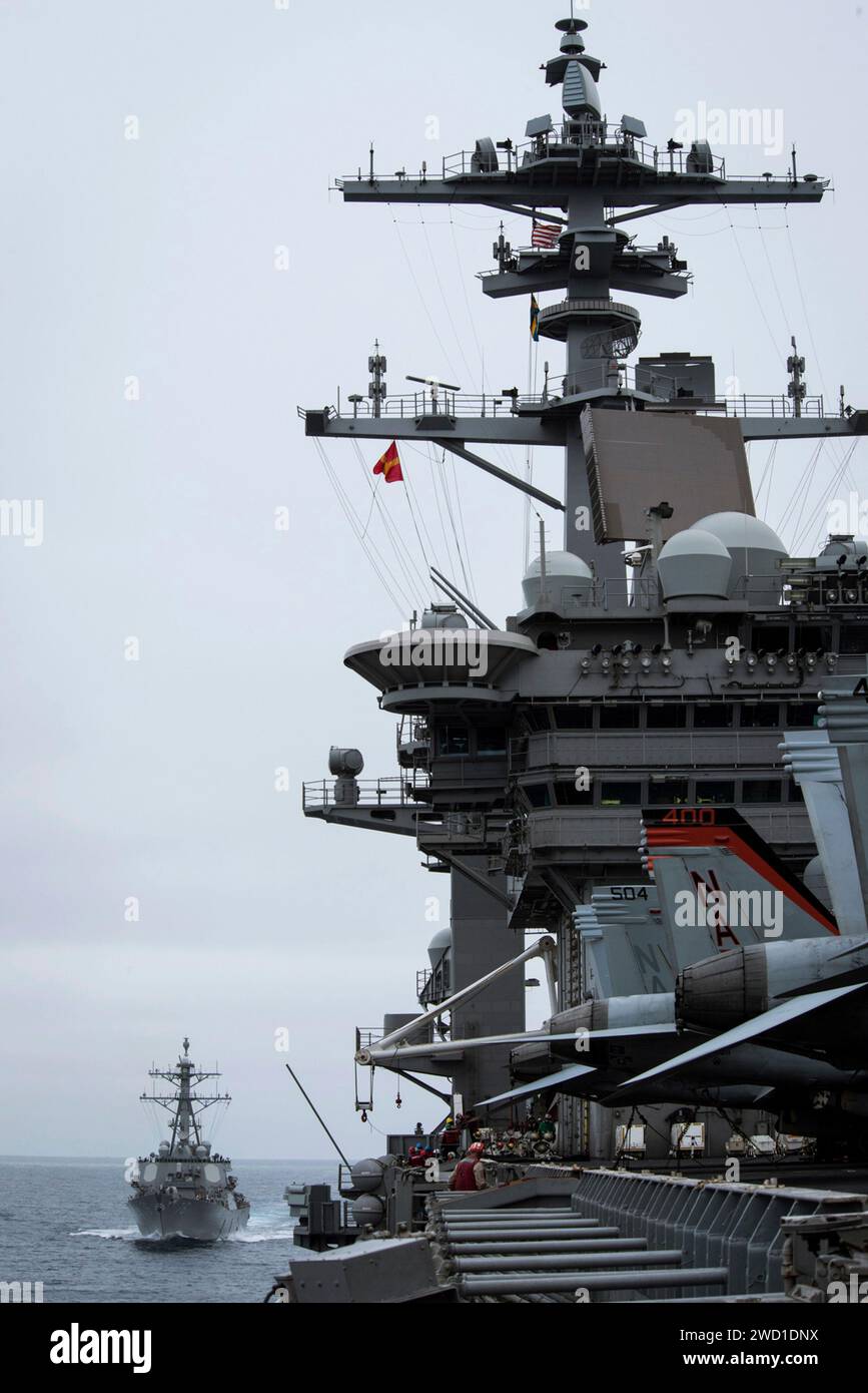 USS Higgins bereitet sich darauf vor, neben dem Flugzeugträger USS Theodore Roosevelt zu ziehen. Stockfoto