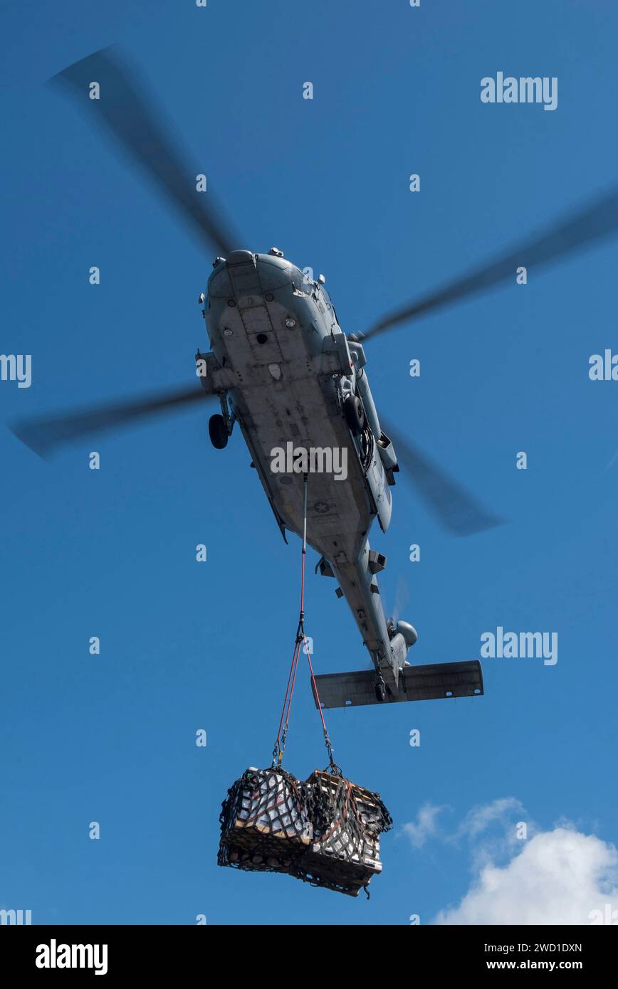 Ein MH-60S Sea Hawk Helikopter transportiert Vorräte während einer vertikalen Auffüllung. Stockfoto