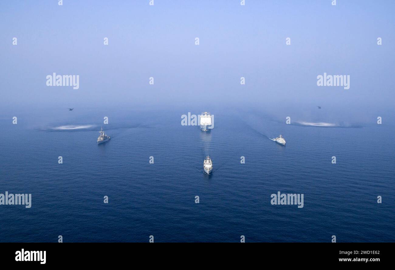 USS Sentry, HMS Bangor, HMS Ledbury und Cardigan Bay Dampf in Formation mit zwei MH-53 Sea Dragon Hubschraubern. Stockfoto