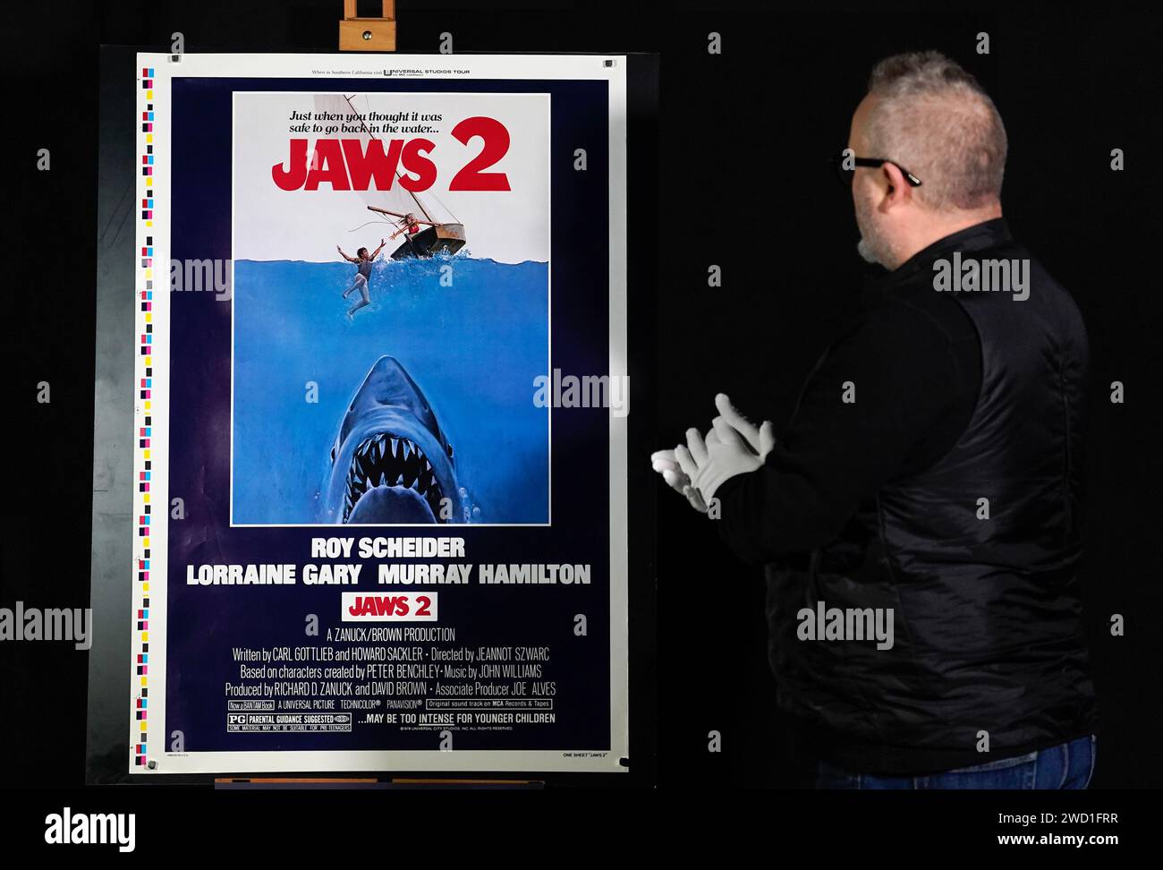 Der Propstore-Poster-Berater Mark Hochman sieht sich den Testdruck eines US-amerikanischen Segelbootes für den Film „Jaws 2“ aus dem Jahr 1978 (geschätzte £5.000 - £10.000) während einer Vorschau für Propstores britische Poster-Auktion im Propstore in Rickmansworth, Hertfordshire, an. Bilddatum: Mittwoch, 17. Januar 2024. Stockfoto