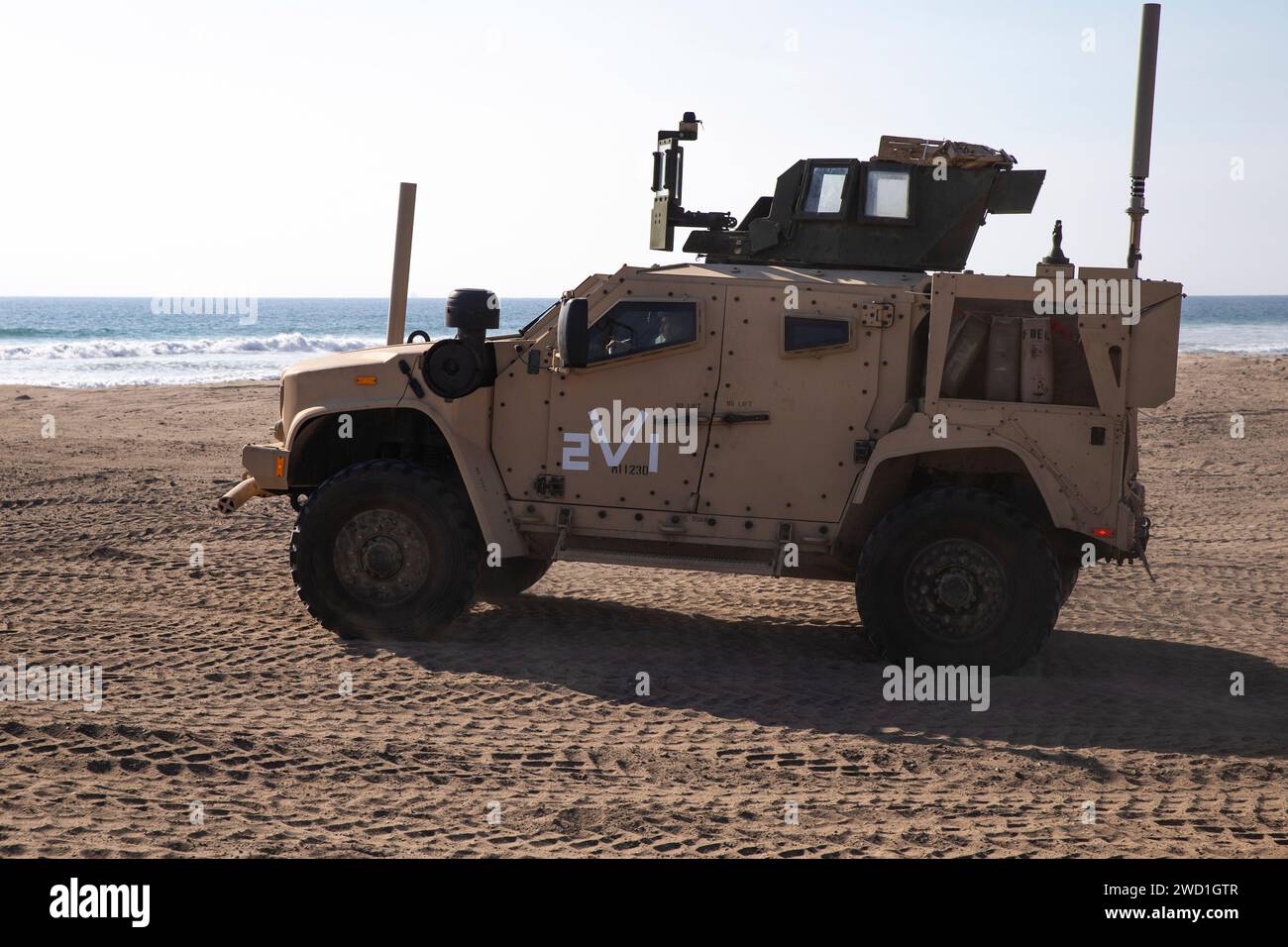 Die US-Marines manövrieren ein gemeinsames leichtes taktisches Fahrzeug durch den Sand. Stockfoto