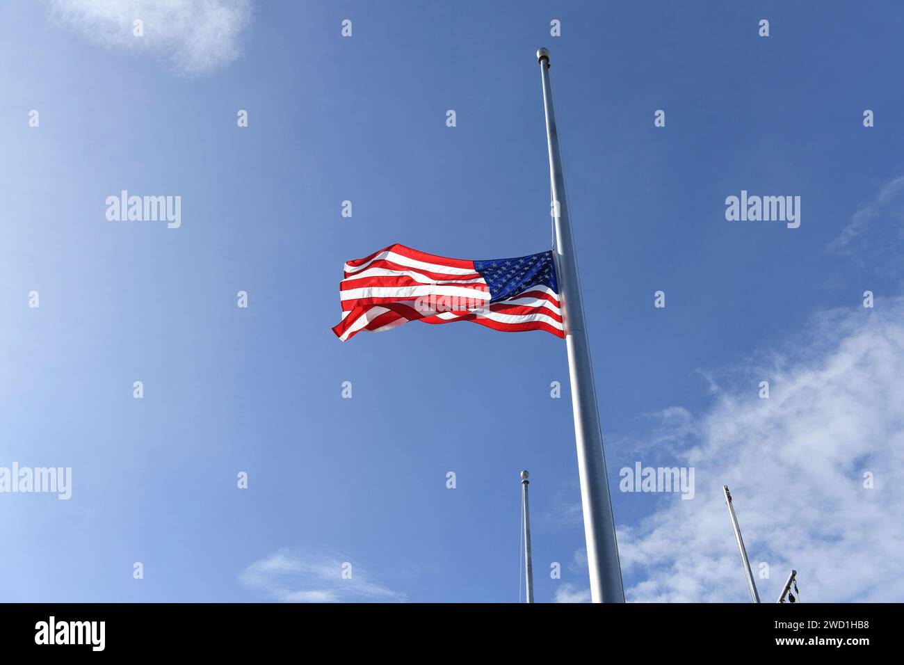 Der nationale Fähnrich fliegt während der Pearl Harbor Memorial Zeremonie mit Halbmast. Stockfoto