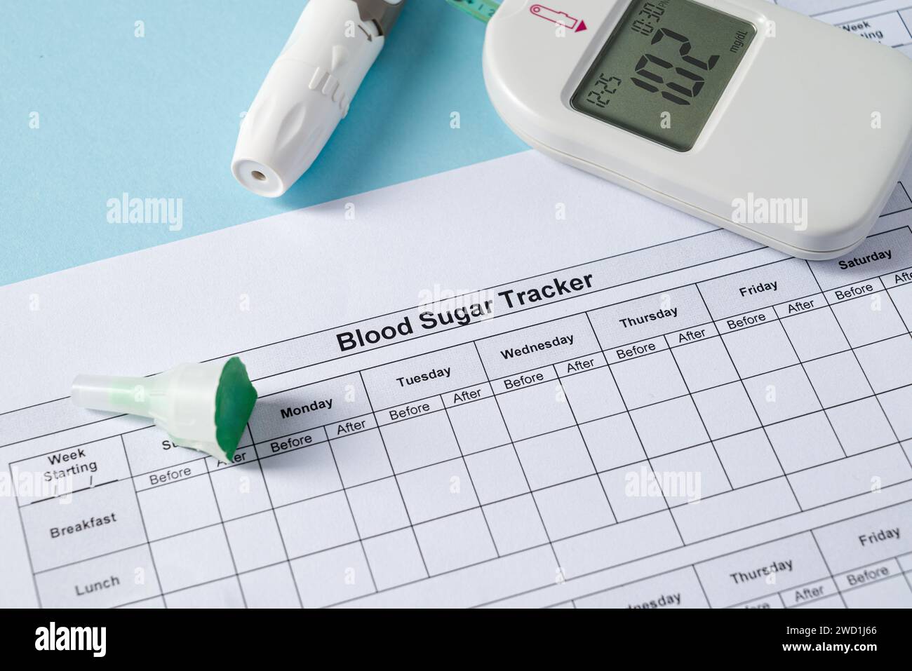 Draufsicht auf Glucometer, Lanzettenstift, Streifen und Blutzucker-Tracker auf blauem Hintergrund. Diabetes-Test-Kit Stockfoto