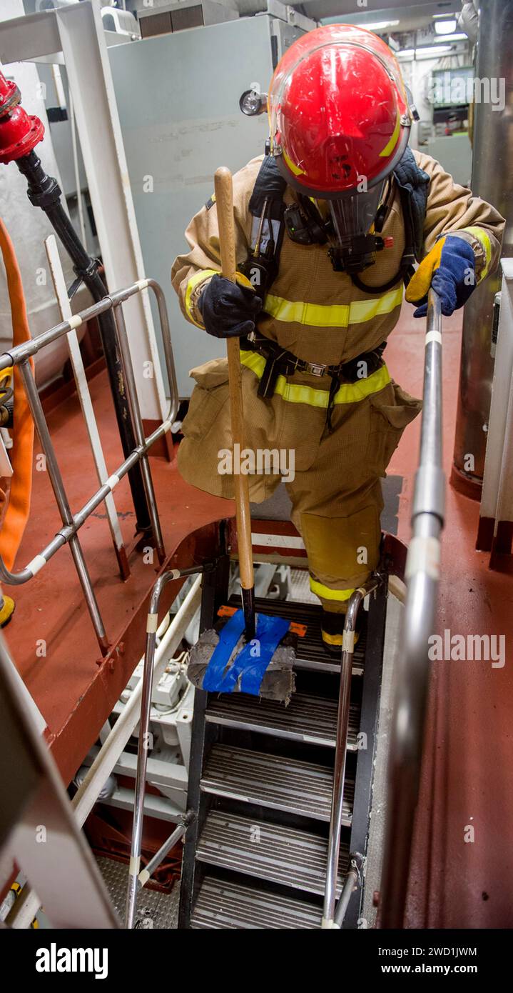Ein Sailor an Bord der USS Lake Champlain testet die Integrität einer Leiter während einer Feuerübung im Hauptraum. Stockfoto