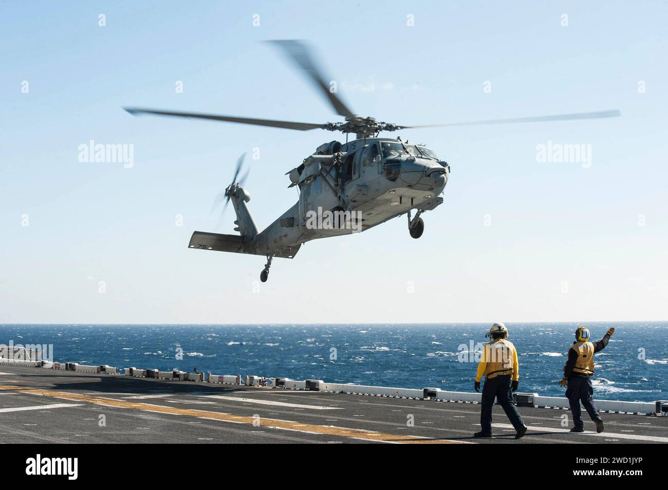 Die Seeleute steuern einen MH-60S Sea Hawk Hubschrauber, der vom Flugdeck der USS Bataan startet. Stockfoto