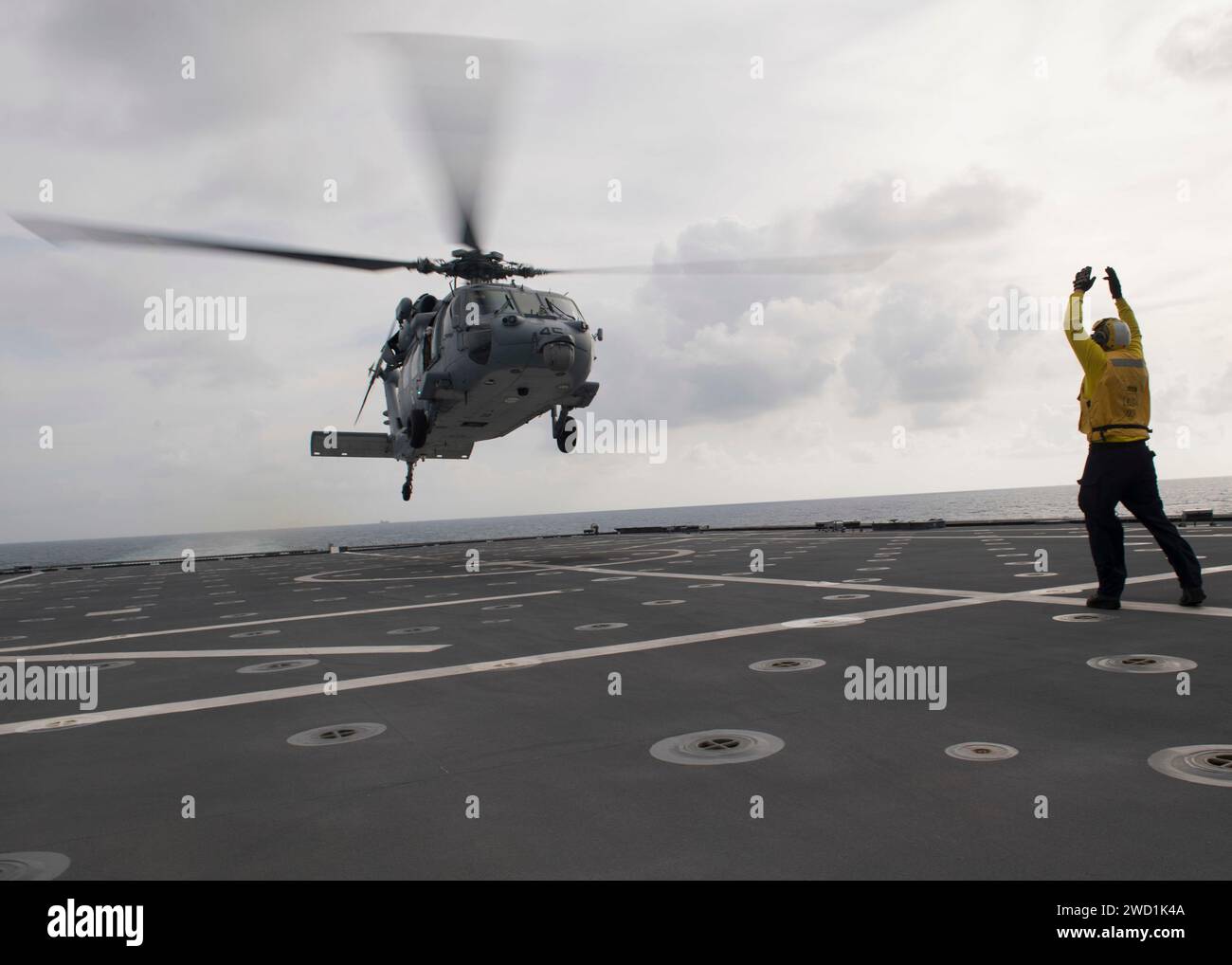 Boatswain's Mate signalisiert einen MH-60S Sea Hawk Hubschrauber an Bord der USS Coronado. Stockfoto