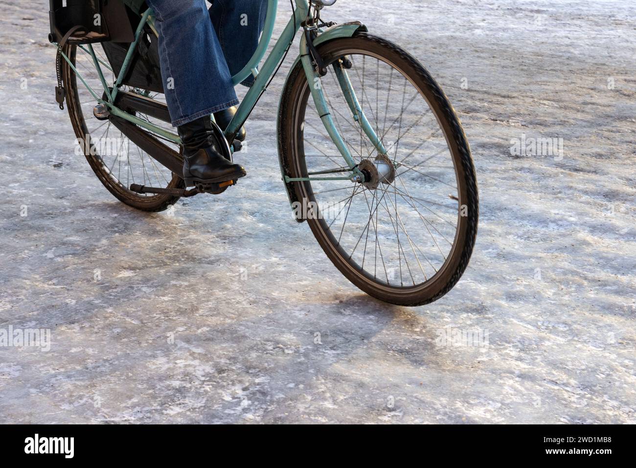 Frau fährt Fahrrad auf einem eisigen Radweg Stockfoto