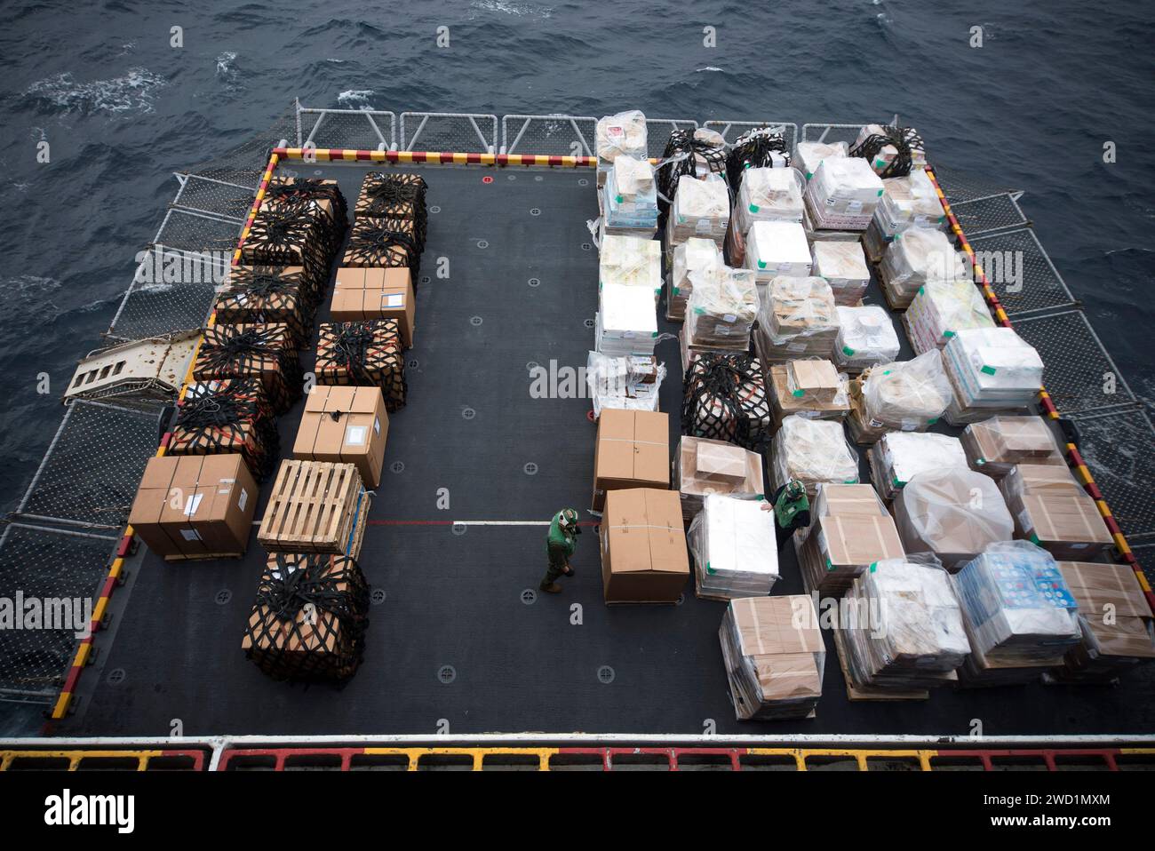 Sailors and Marines inspizieren Vorratspaletten auf dem Aufzug der USS Bonhomme Richard. Stockfoto