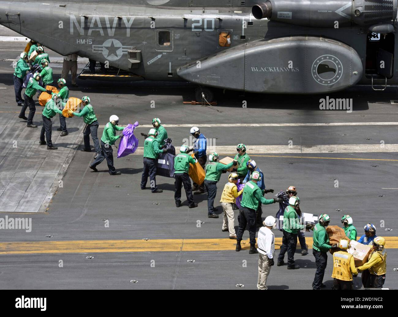 Seeleute transportieren Post von einem MH-53E Sea Dragon Helikopter an Bord der USS George H.W. Bush. Stockfoto