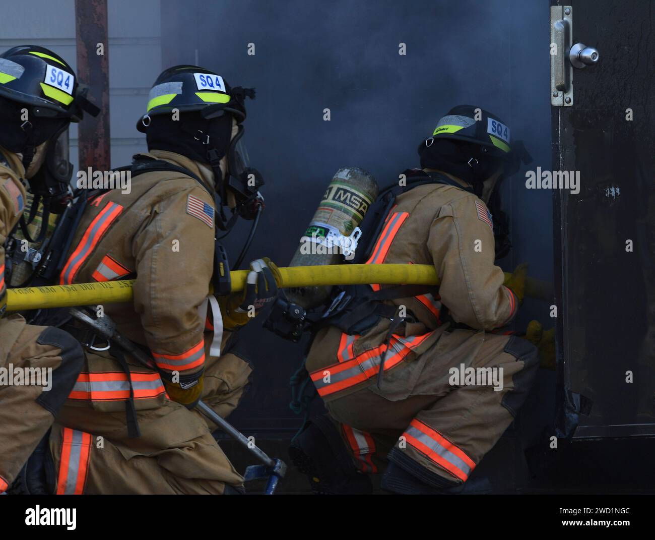 Seeleute betreten ein brennendes Gebäude für Brandversuche an der Southside Regional Fire Academy. Stockfoto