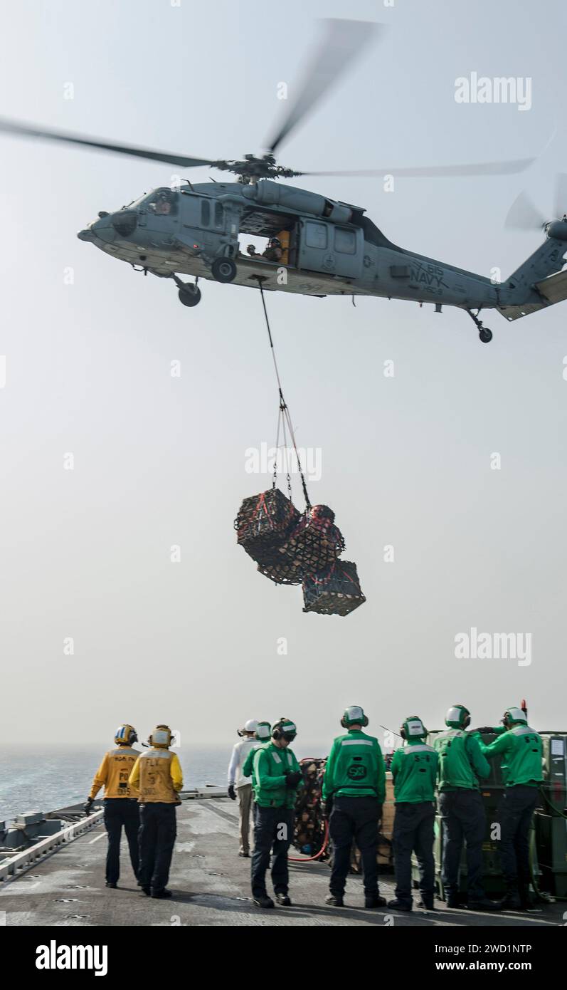 Ein MH-60S Sea Hawk Helikopter transportiert Fracht während einer vertikalen Auffüllung an Bord der USS George H.W. Bush. Stockfoto