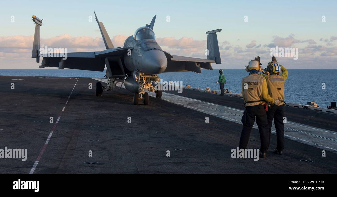 Aviation Boatswain's Mates leiten eine F/A-18E Super Hornet an Bord der USS Ronald Reagan. Stockfoto