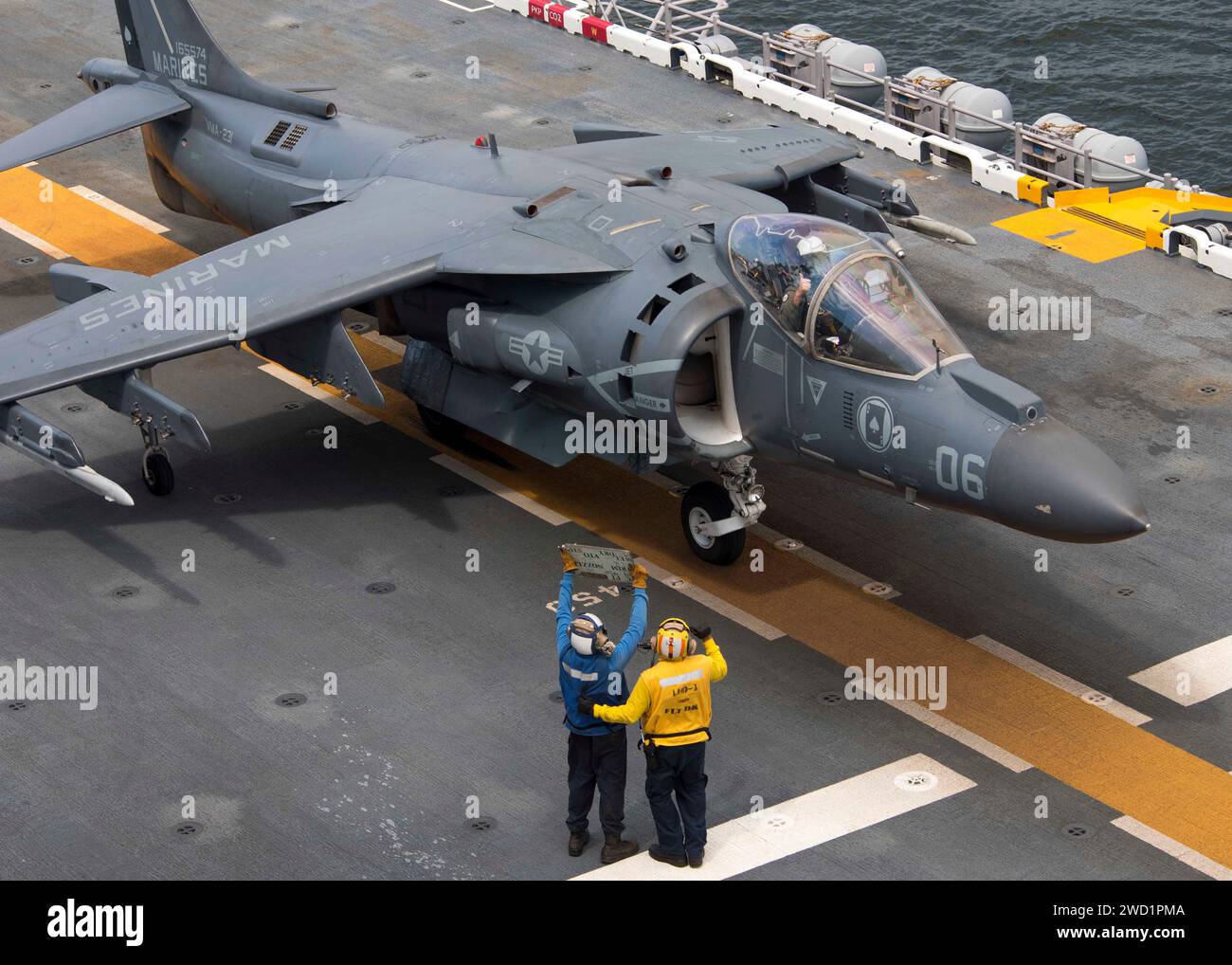 Airman benutzt ein Tote Board, um mit dem Piloten einer AV-8B Harrier an Bord der USS Wasp zu kommunizieren. Stockfoto