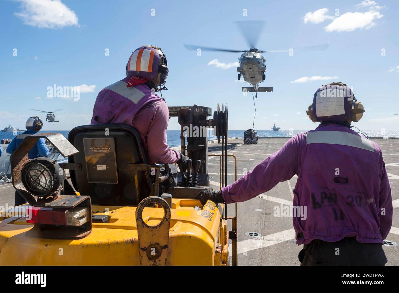 Ein MH-60S Sea Hawk Hubschrauber wirft Frachtpaletten auf dem Flugdeck der USS Green Bay ab. Stockfoto