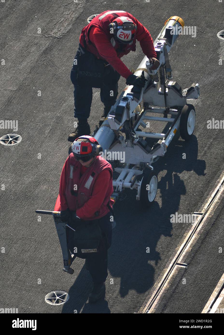 Die Flugzeugabwehrmänner transportieren Geschütze auf dem Flugdeck des Flugzeugträgers USS Nimitz. Stockfoto