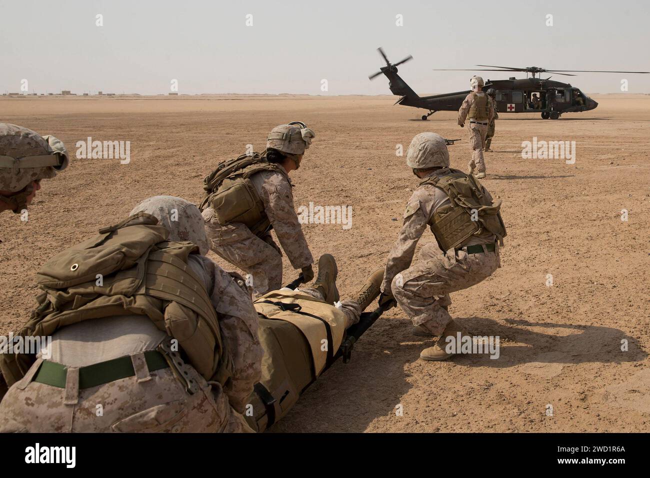 US-Seeleute und Marines tragen einen Marine mit einer simulierten Verletzung an einem UH-60L Black Hawk. Stockfoto