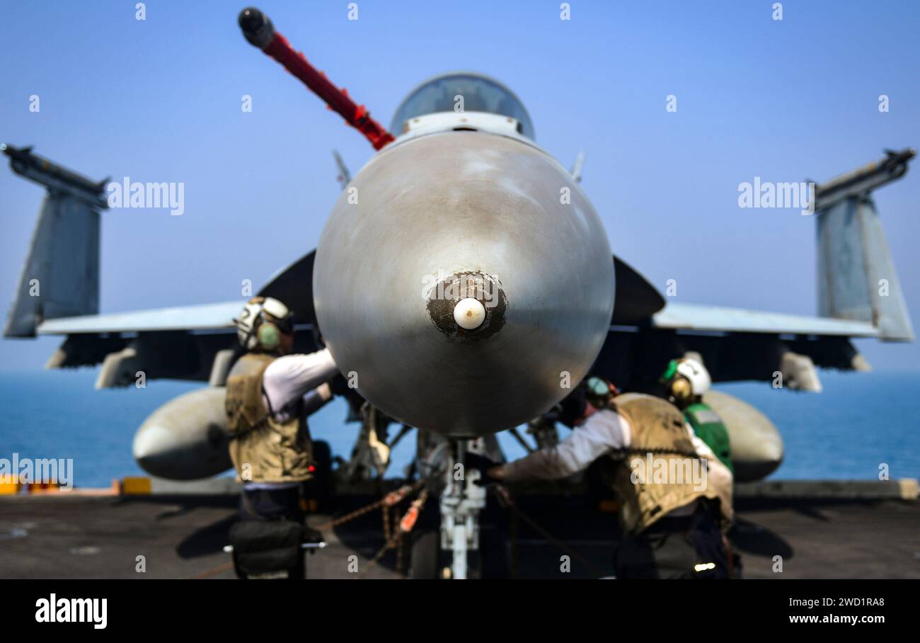 Die Matrosen führen letzte Prüfungen an einer F/A-18E Super Hornet an Bord der USS Nimitz durch. Stockfoto