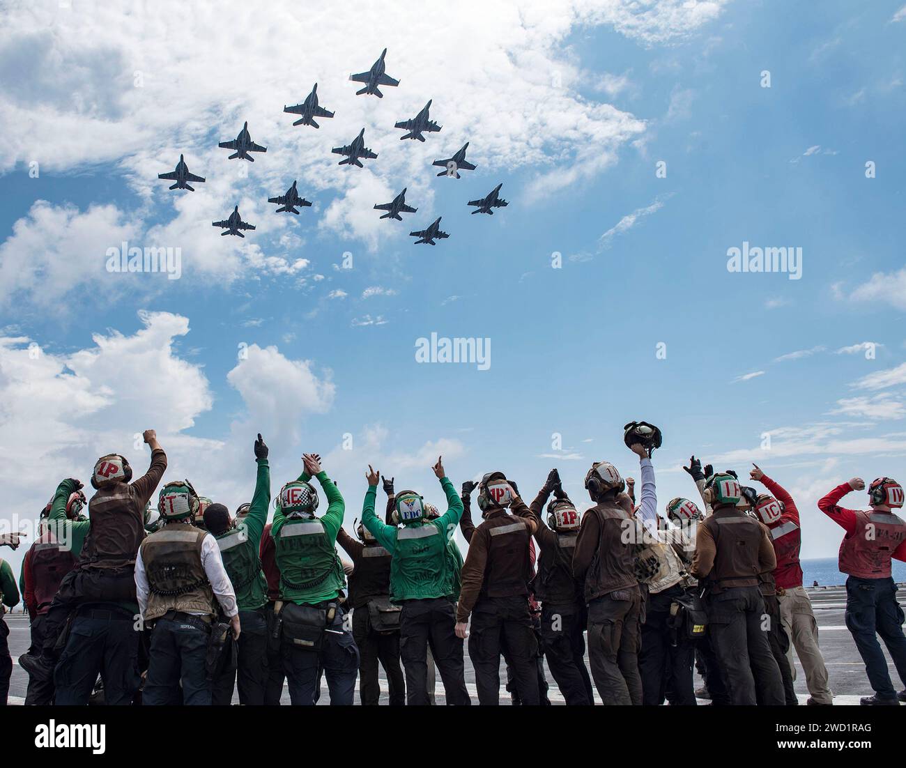 Die Segler feiern, als die ihrer Staffel zugeordneten Flugzeuge über den Flugzeugträger USS George H.W. Bush fliegen. Stockfoto