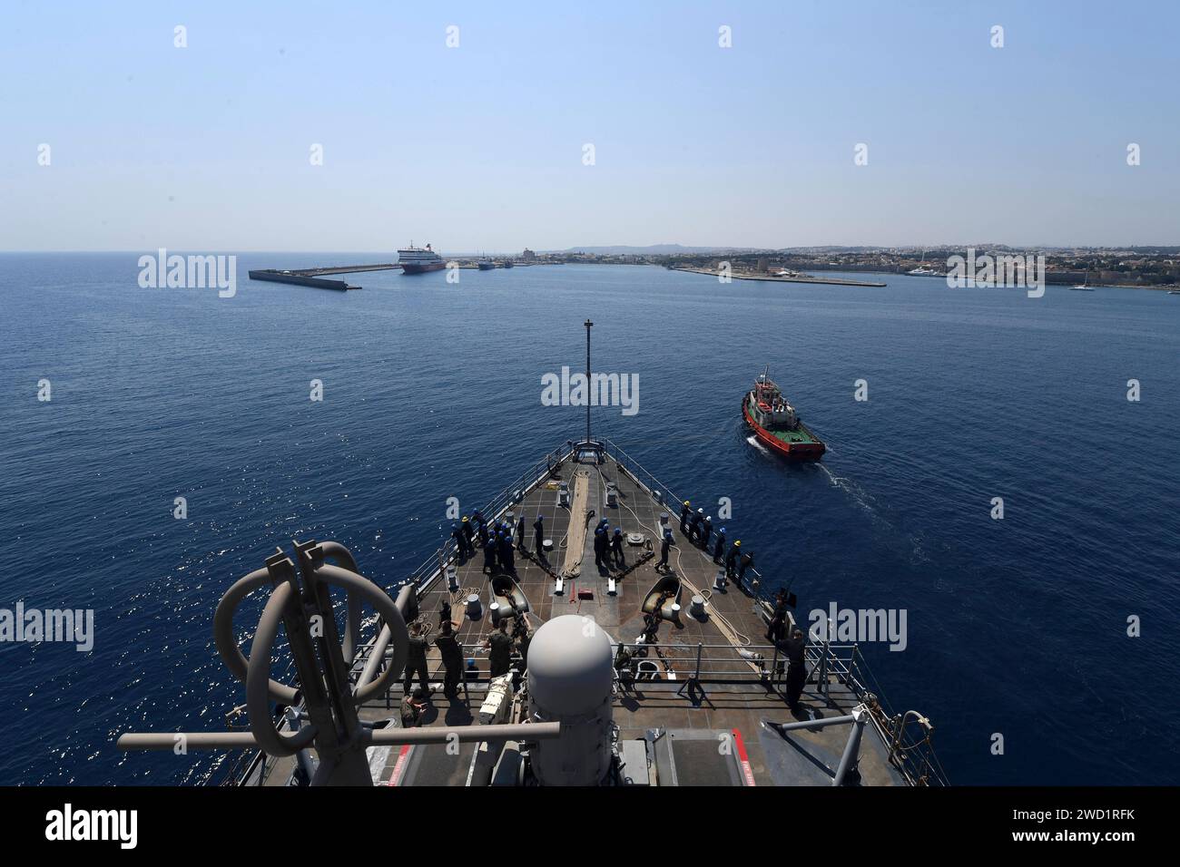 Ein griechisches Schleppboot hilft dem Amphibienschiff USS Carter Hall beim Anfahren in den Hafen von Rhodos, Griechenland. Stockfoto