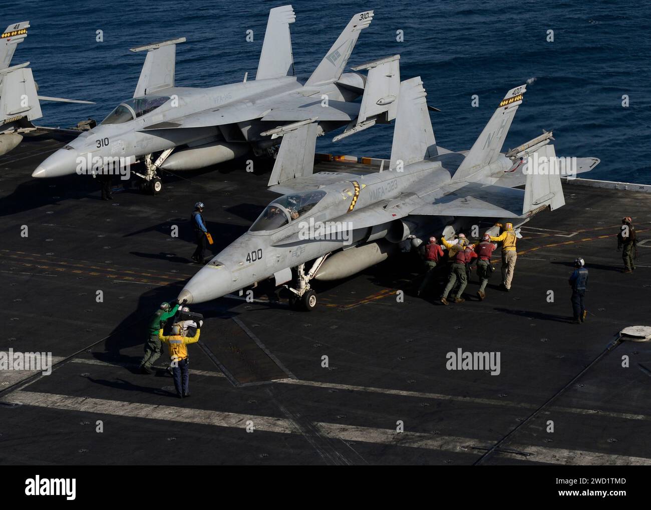 US-Seeleute und Marines schieben auf einer F/A-18C Hornet auf dem Flugdeck der USS Nimitz zurück. Stockfoto
