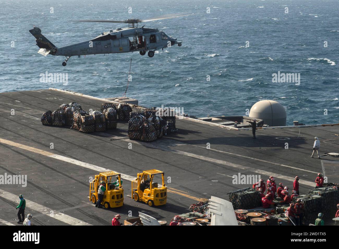 Ein MH-60S Sea Hawk Helikopter transportiert die Vorräte zum Flugzeugträger USS Nimitz. Stockfoto