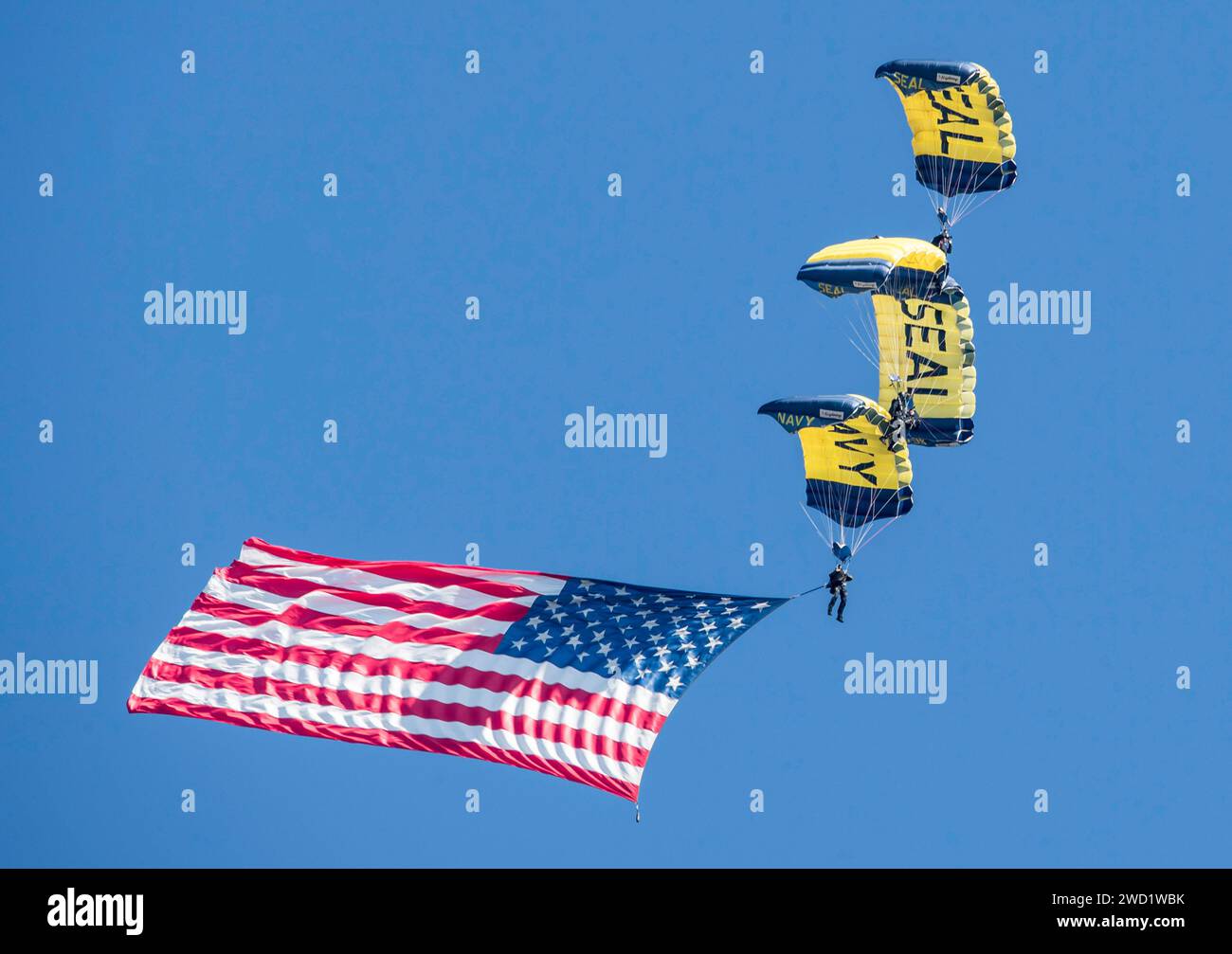 Mitglieder des Fallschirmteams der US Navy, die Leap Frogs, bauen eine Diamantenformation mit amerikanischer Flagge. Stockfoto