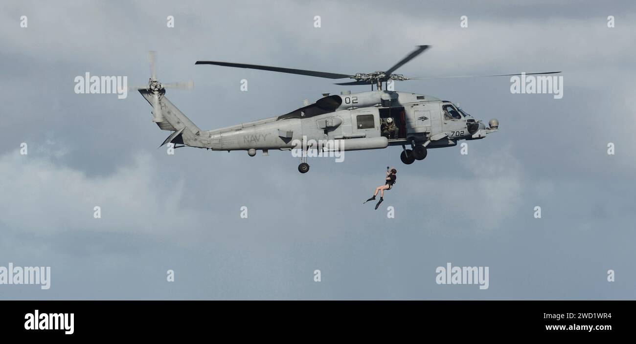 Seeleute demonstrieren Rettungsschwimmer mit einem MH-60R Sea Hawk Hubschrauber. Stockfoto