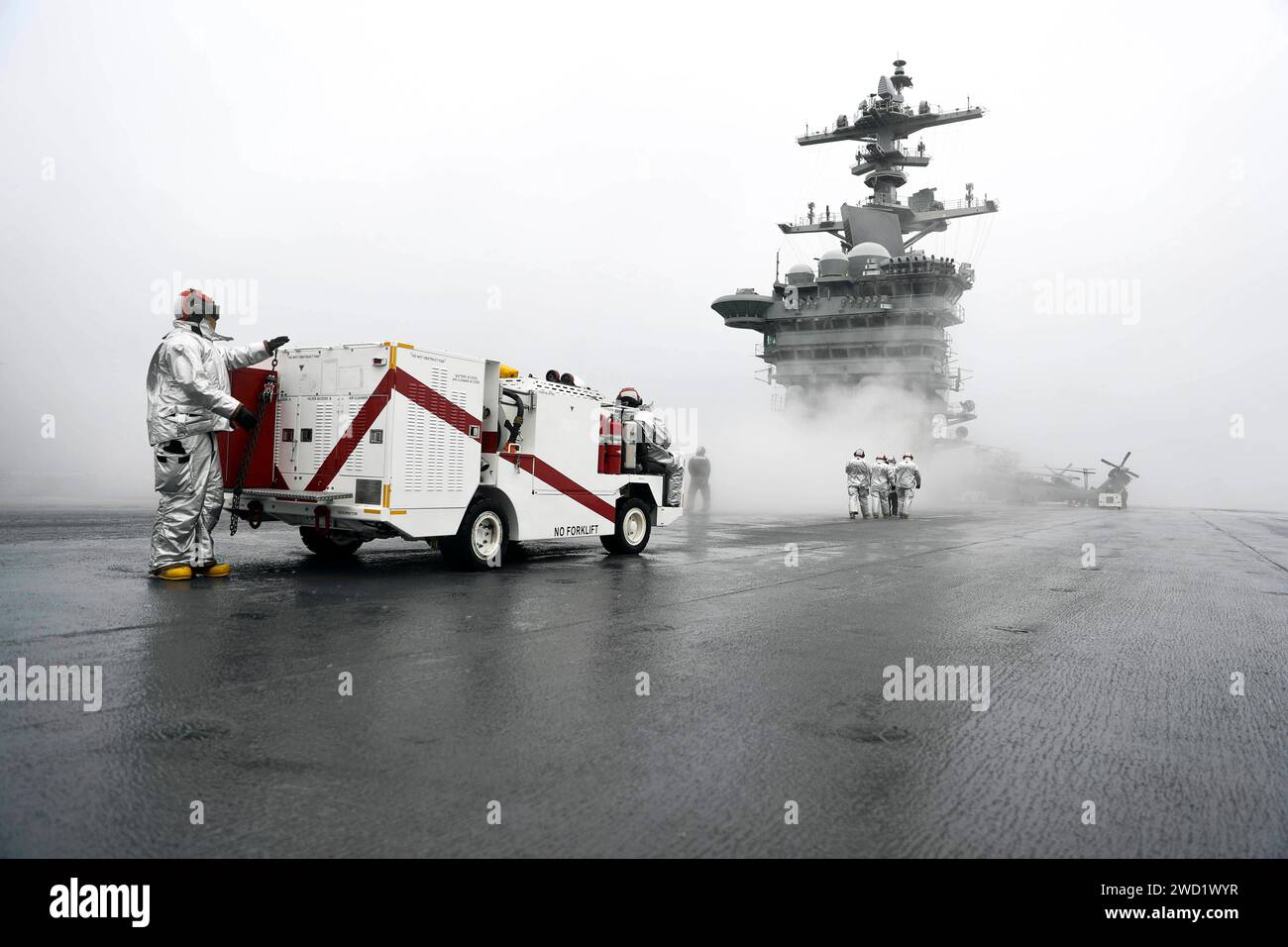 Seeleute an Bord der USS Abraham Lincoln sind auf dem Flugdeck für Notfälle bereit. Stockfoto