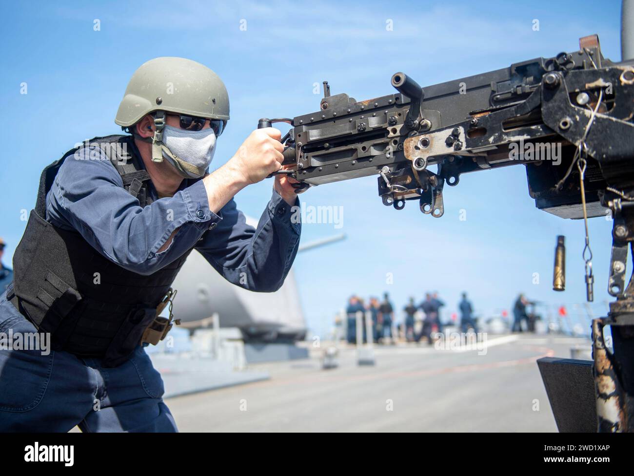 Fire Controlman lädt während einer Feuerübung Munition in ein 50 Kaliber Maschinengewehr. Stockfoto