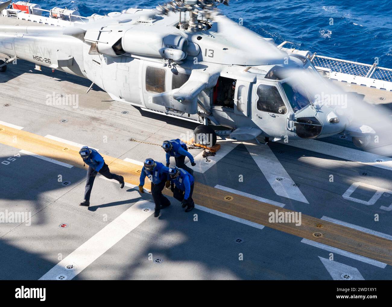 Seeleute räumen einen MH-60S Sea Hawk an Bord des amphibischen Angriffsschiffs USS Iwo Jima ab. Stockfoto